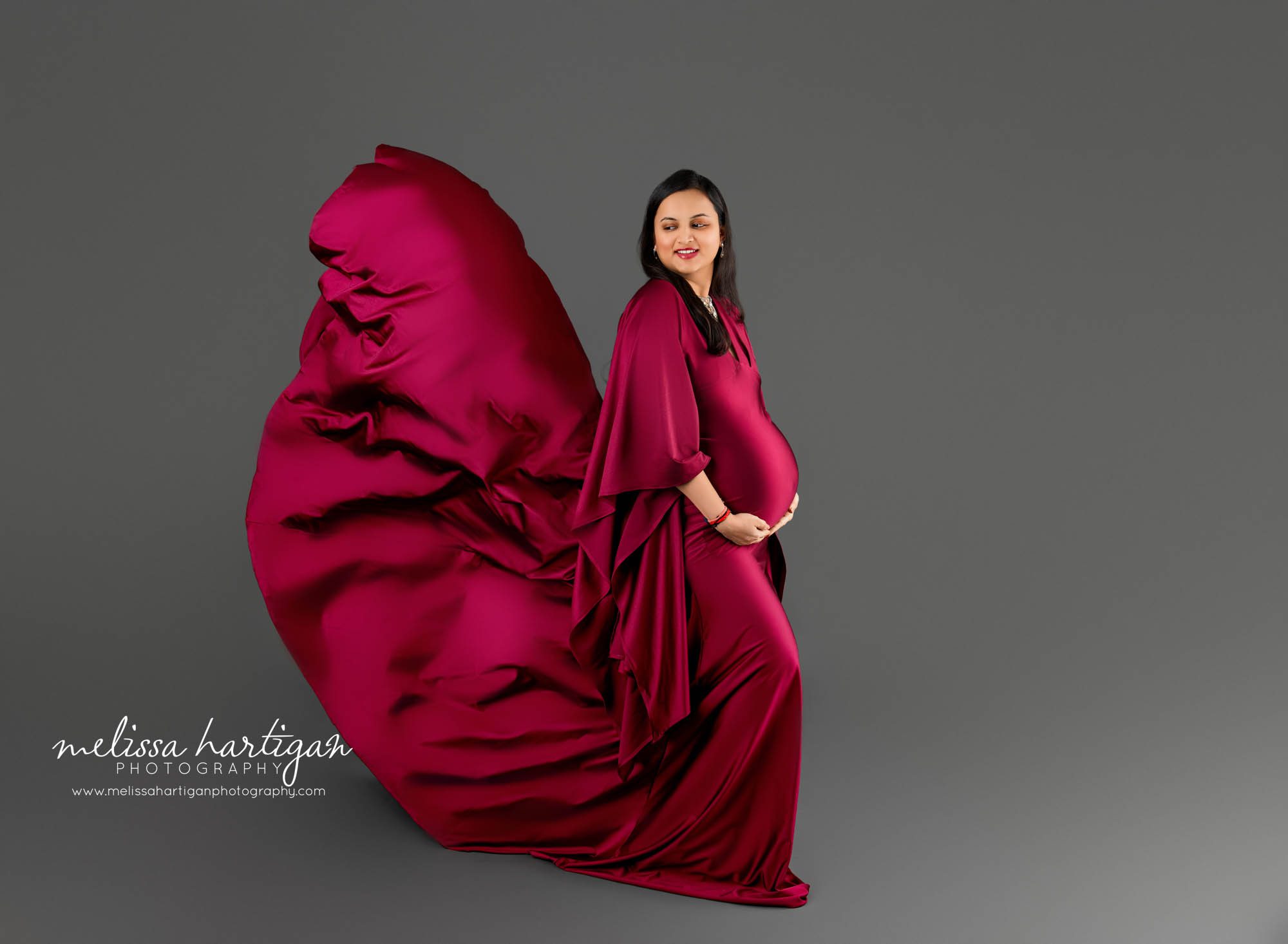 expecting mom in maternity photoshoot posing with maternity gown tossed Maternity Photography South Windsor