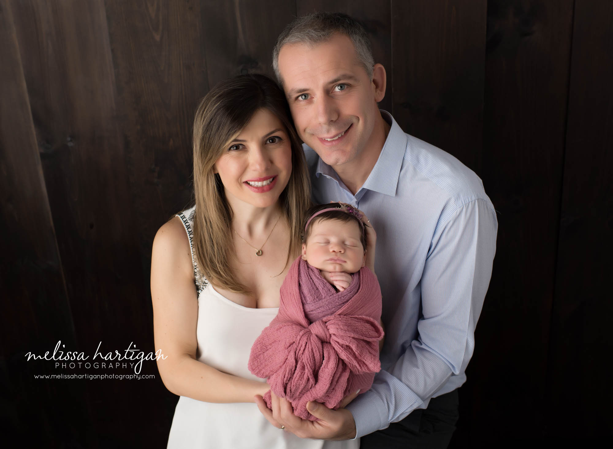 Mom and dad posed together with newborn daughter