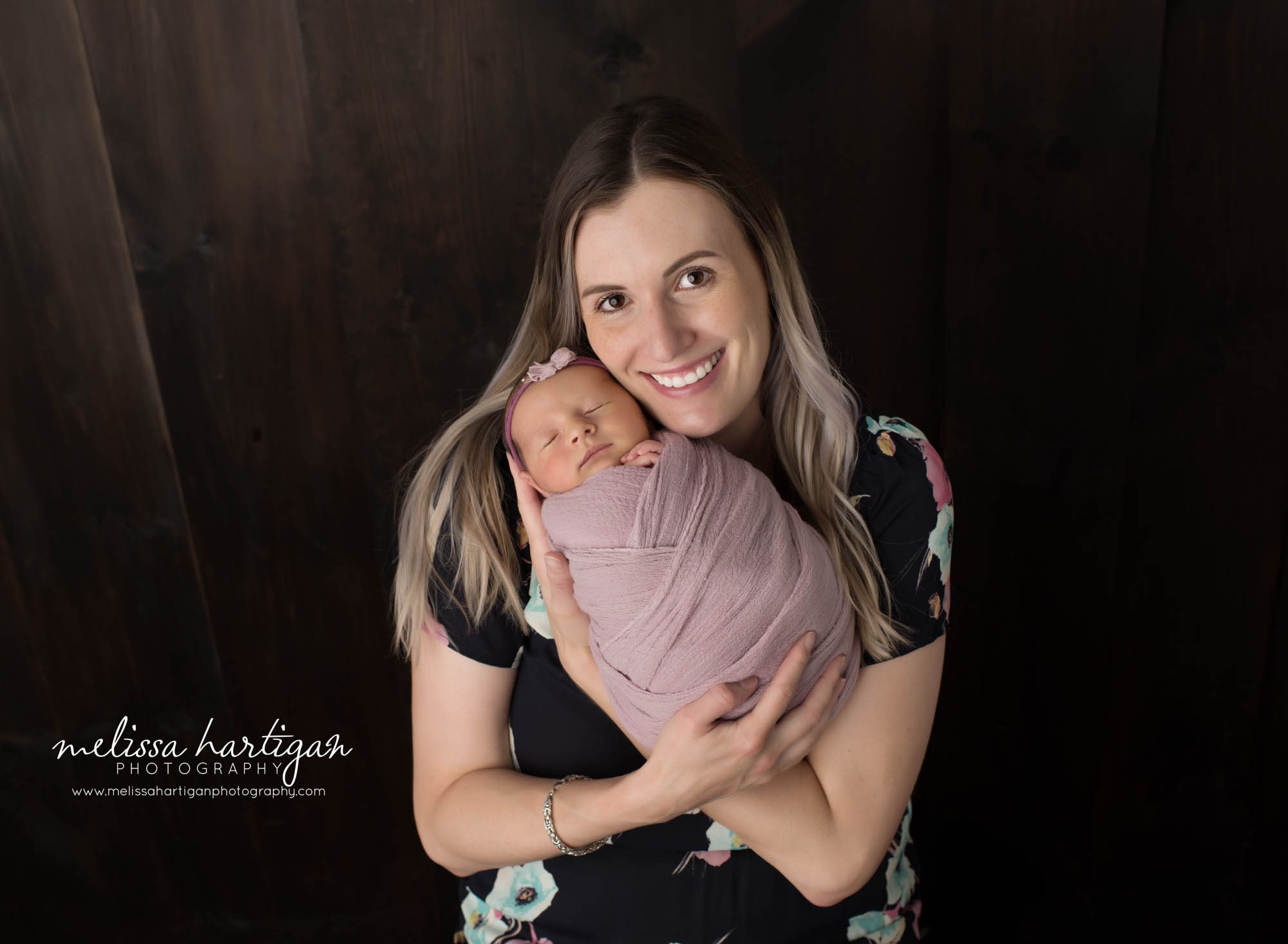 mom smiling holding newborn daughter Newborn Photography Weston CT