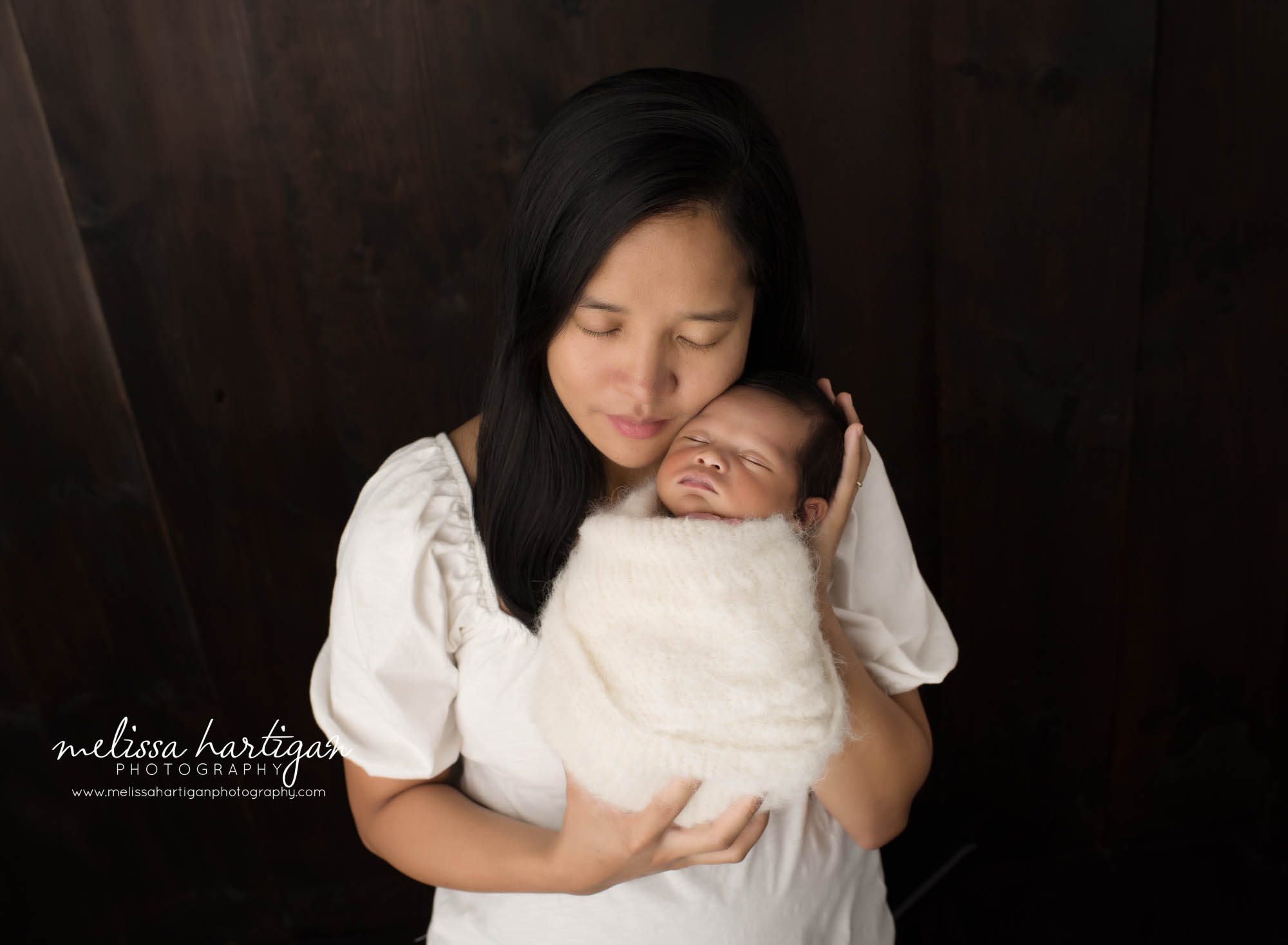 mom holding swaddled newborn son