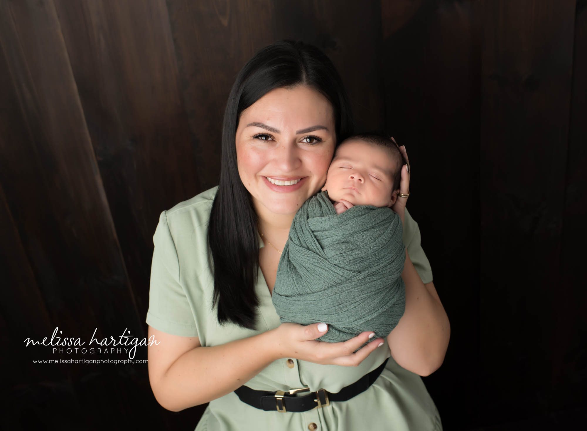 mom holding newborn son in parents pose