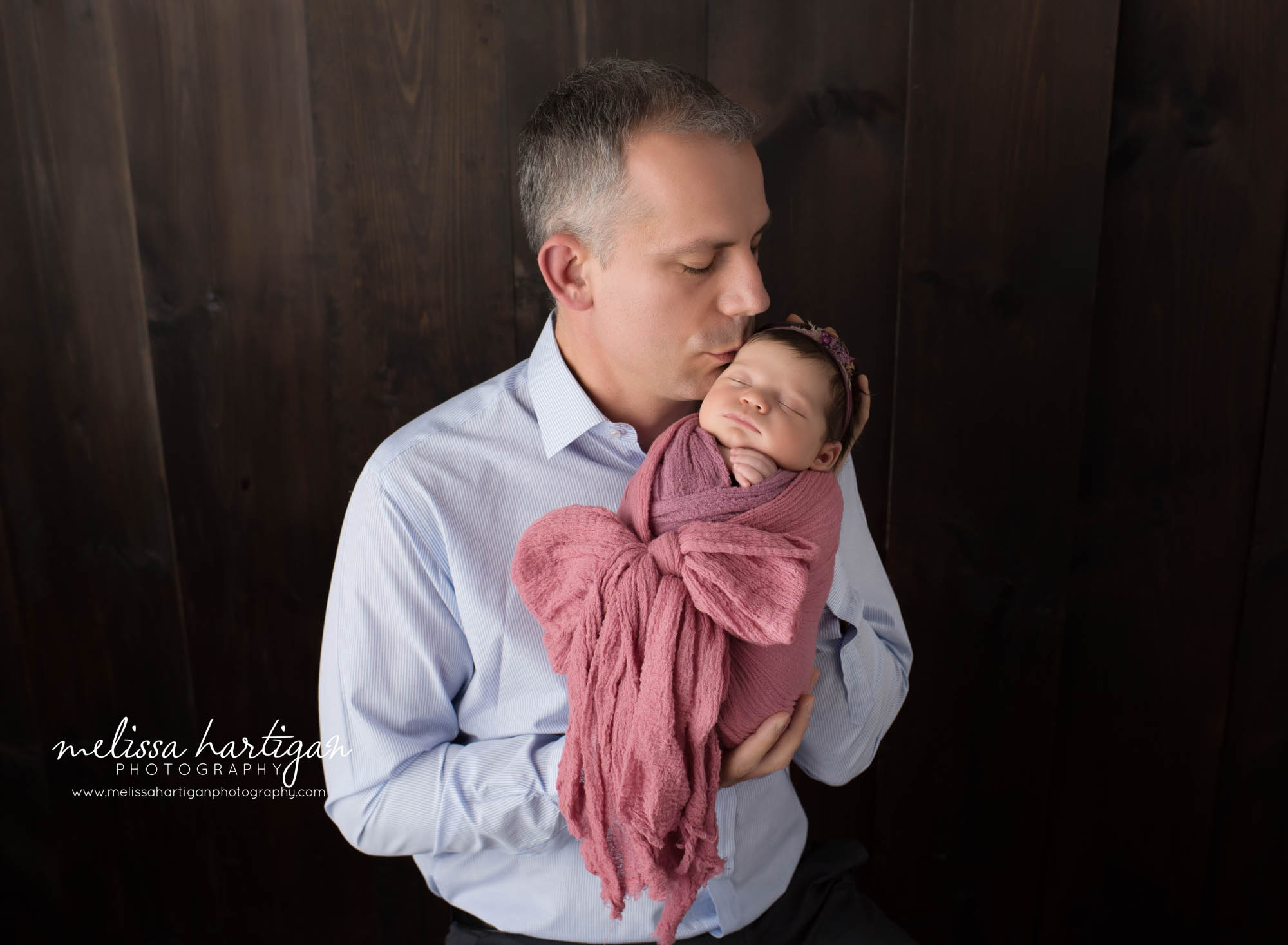 Dad giving newborn daughter a kiss Newborn Photography Farmington CT