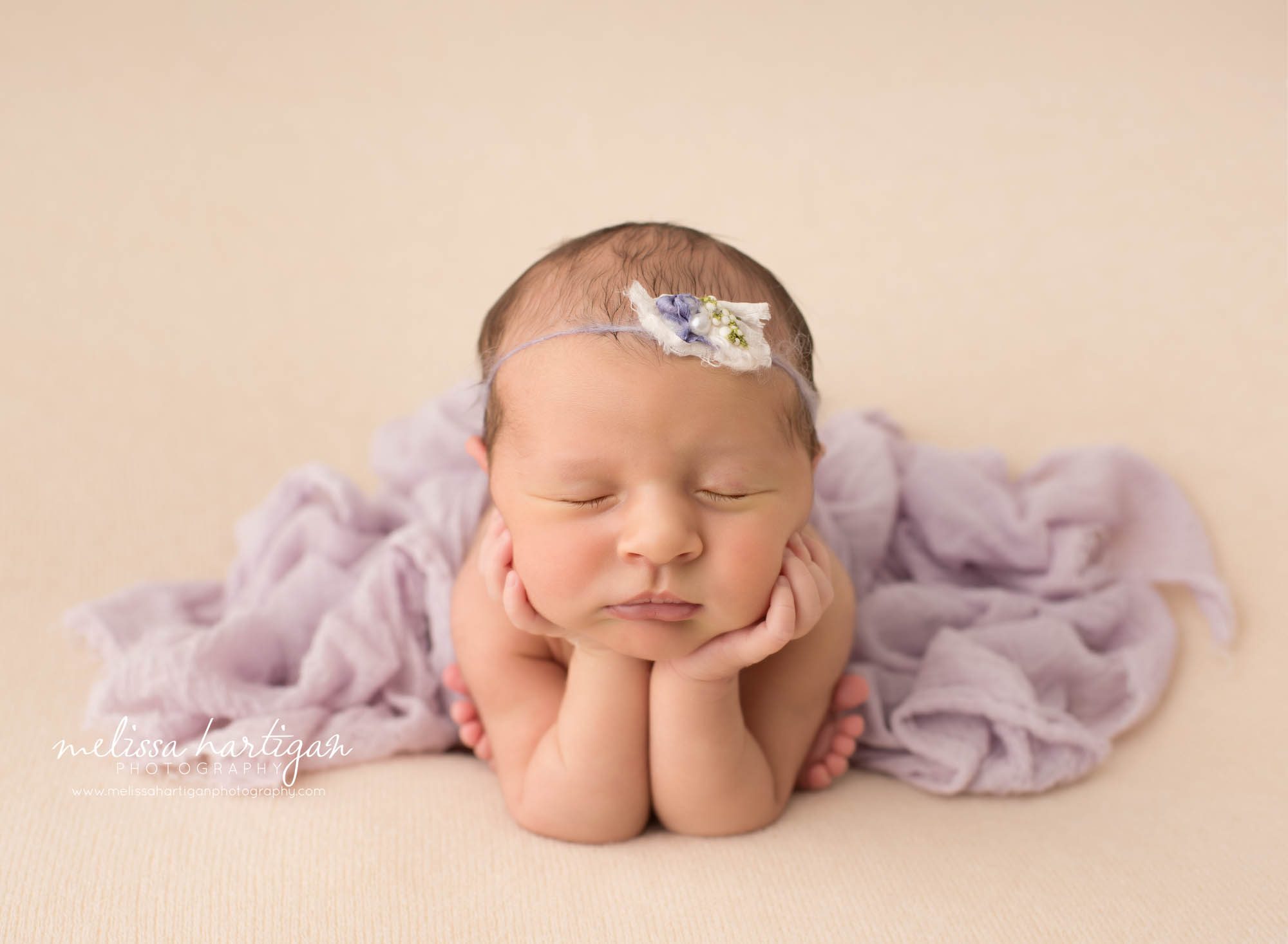 newborn baby girl posed froggy pose draped with purple wrap Newborn Photography Weston CT