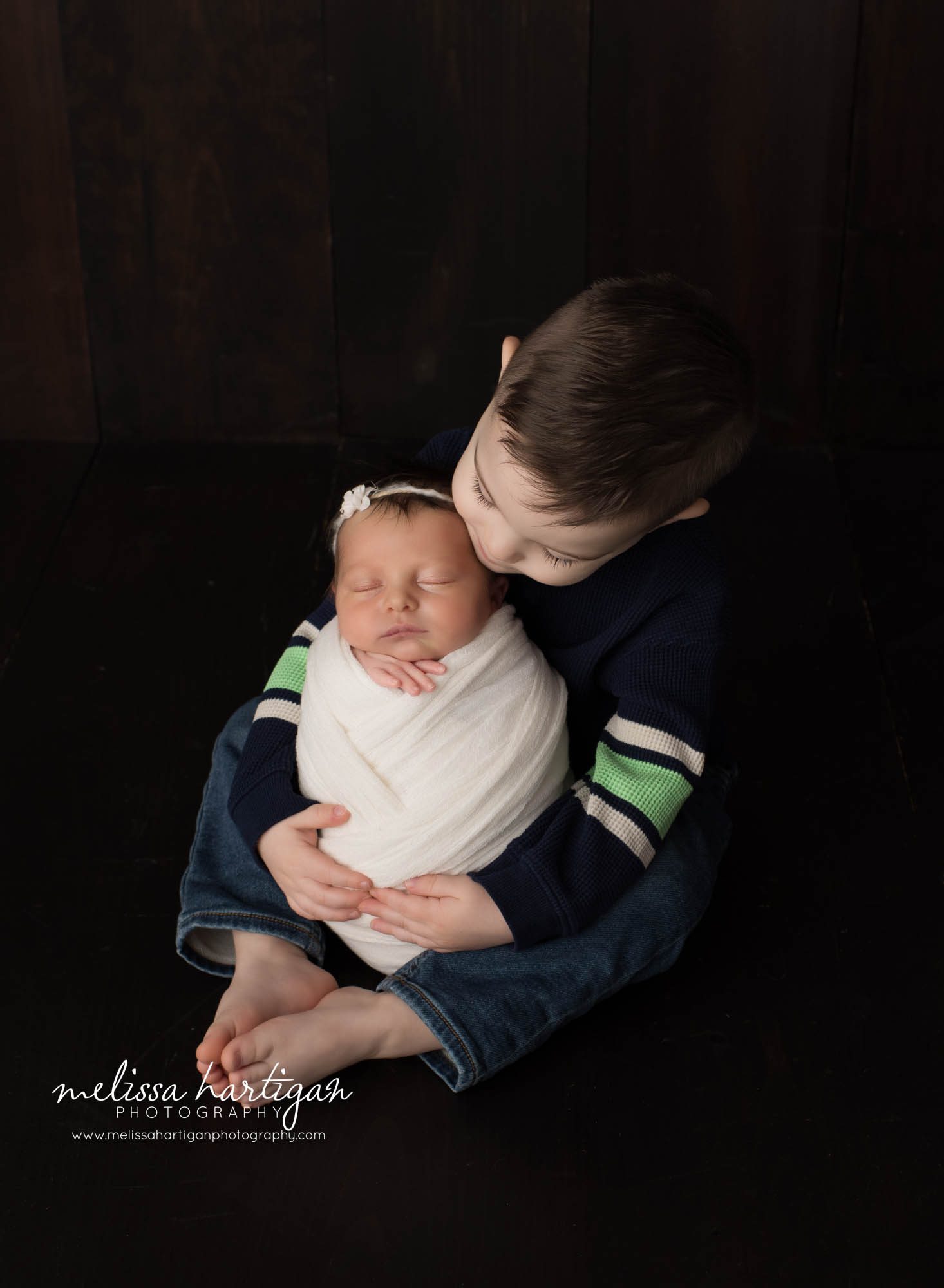 Big brother sitting holding baby sister