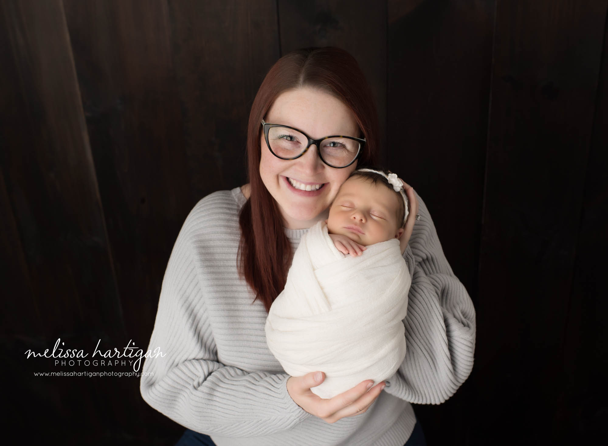 mom happy smiling holding newborn daughter in parents pose Vernon CT Newborn Photography