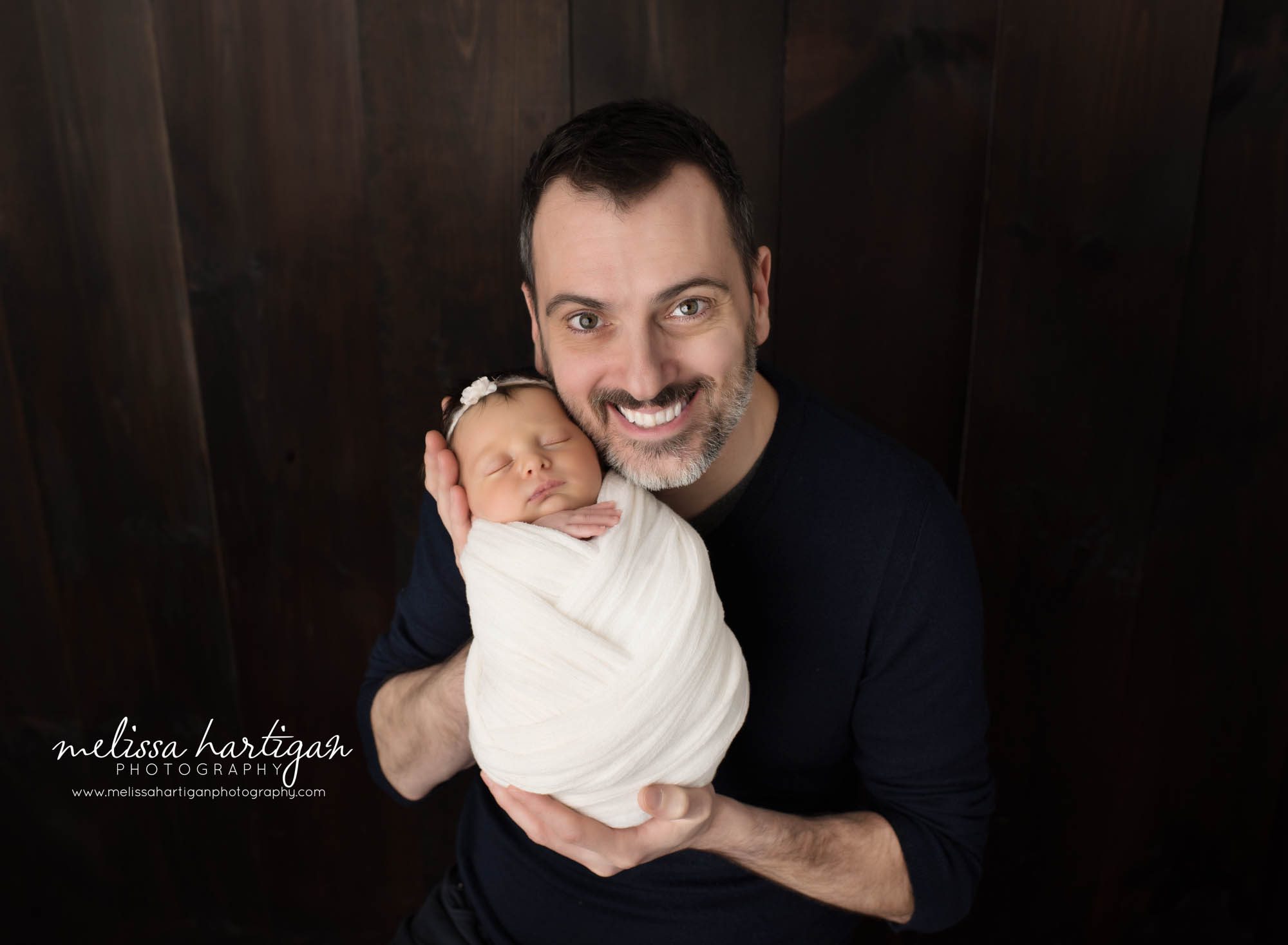 Dad happy smiling holding swaddled newborn daughter in parents pose Vernon CT Newborn Photography