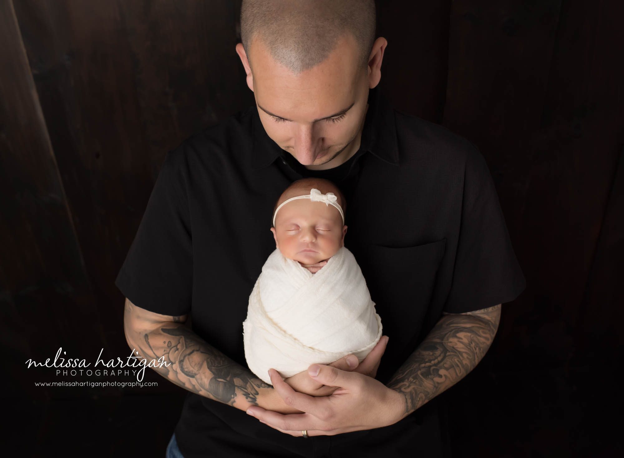 Dad holding newborn daughter in parents pose