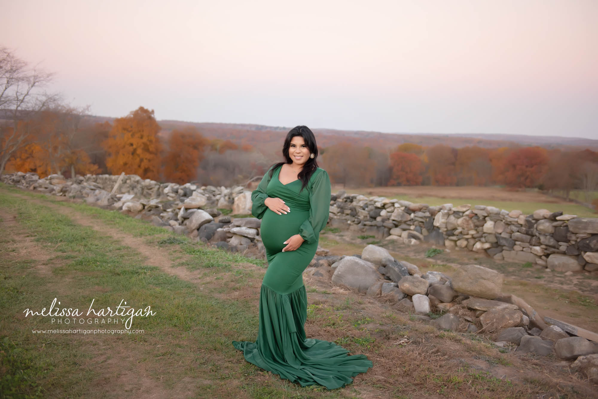 Mom posed holding baby bump wearing green form fitted maternity gown Maternity Photography Plainville CT