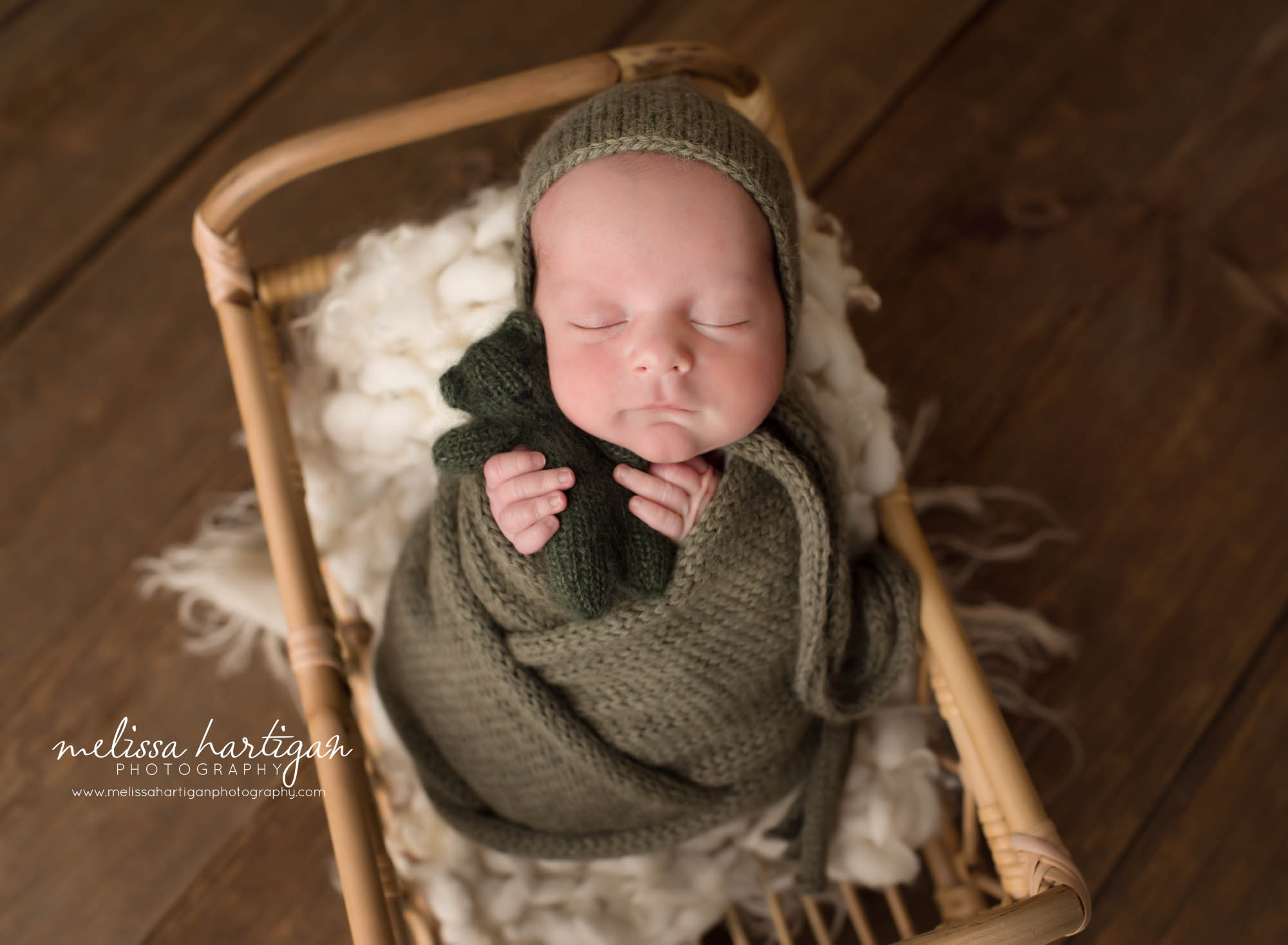 Newborn baby boy swaddled in green knit wrap holding green knit teddy Collinsville CT Newborn Photography