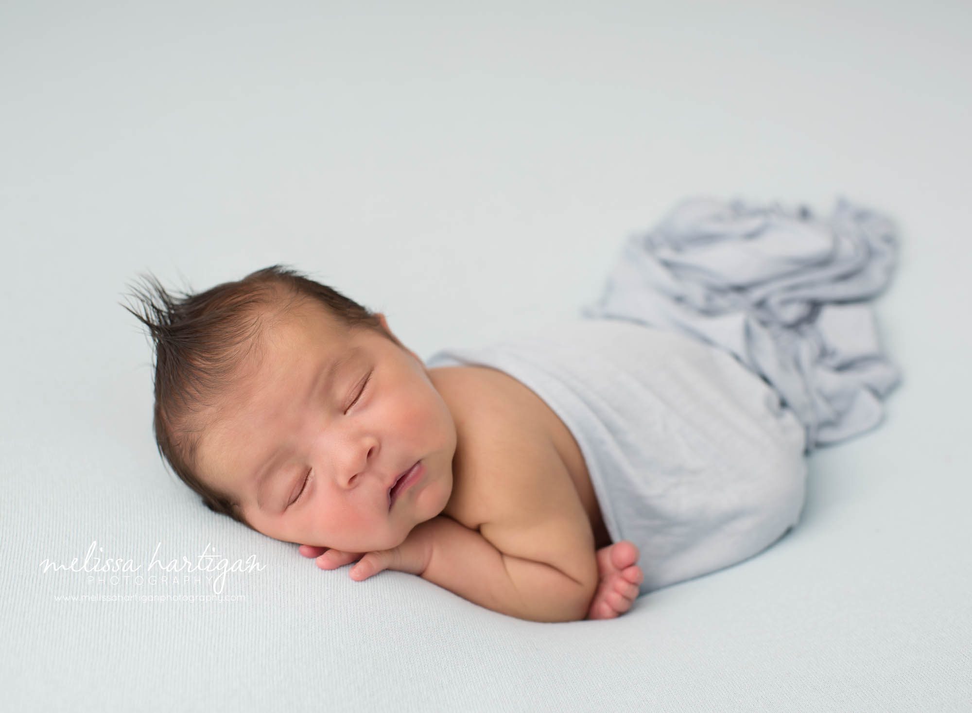 Newborn baby boy posed on tummy with blue draping layer Newborn Photography Norwich CT