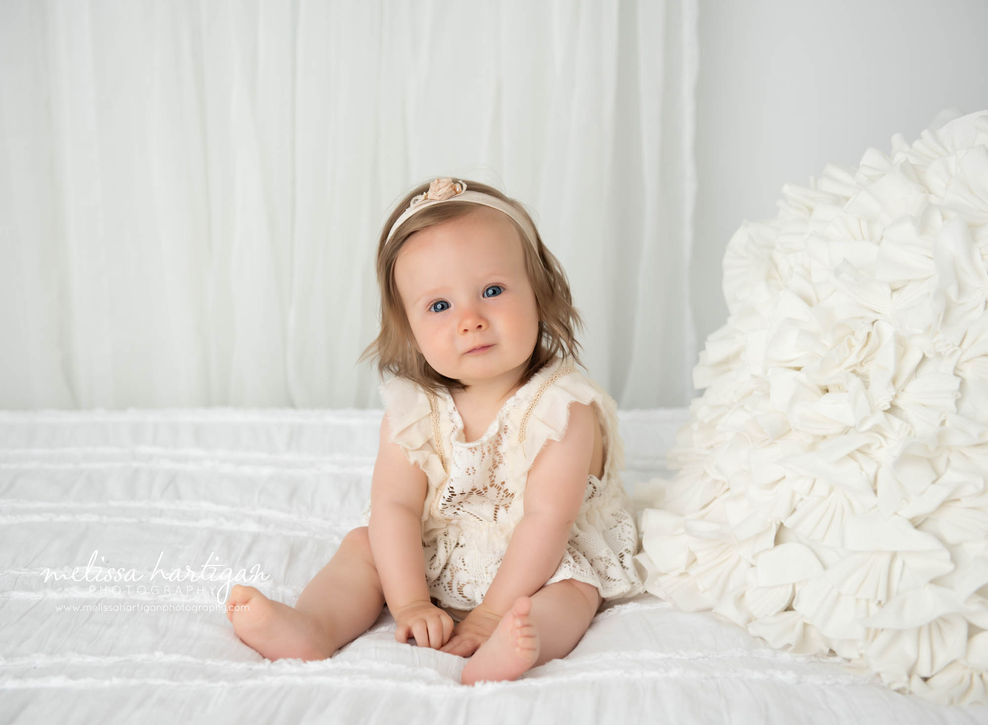 Baby girl sitting up on bed in studio for milestone photoshoot Tolland CT Baby Photographer