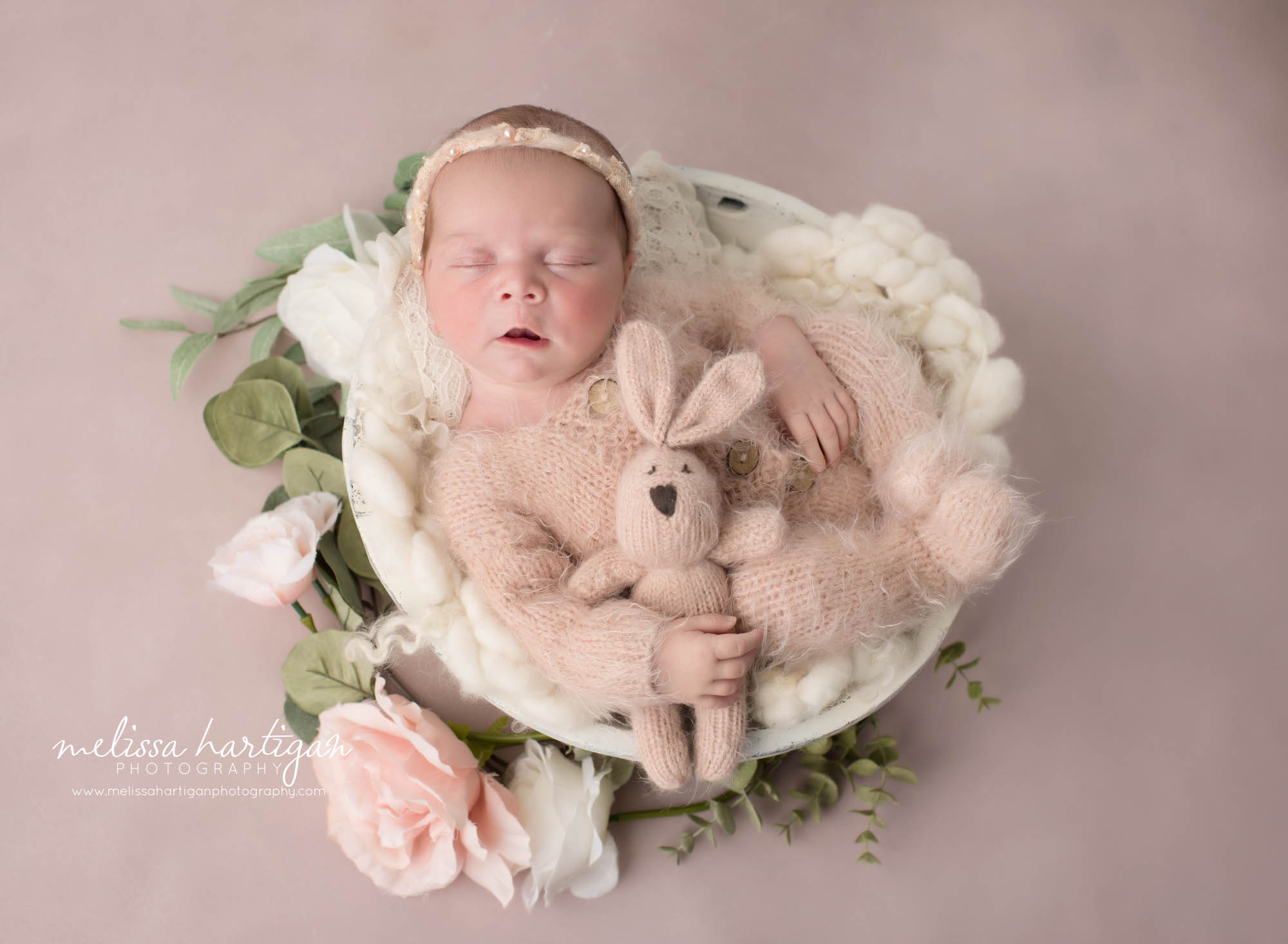 Newborn baby girl posed in wooden bow wearing pink outfit holding bunny prop Newborn Photography Ivoryton CT