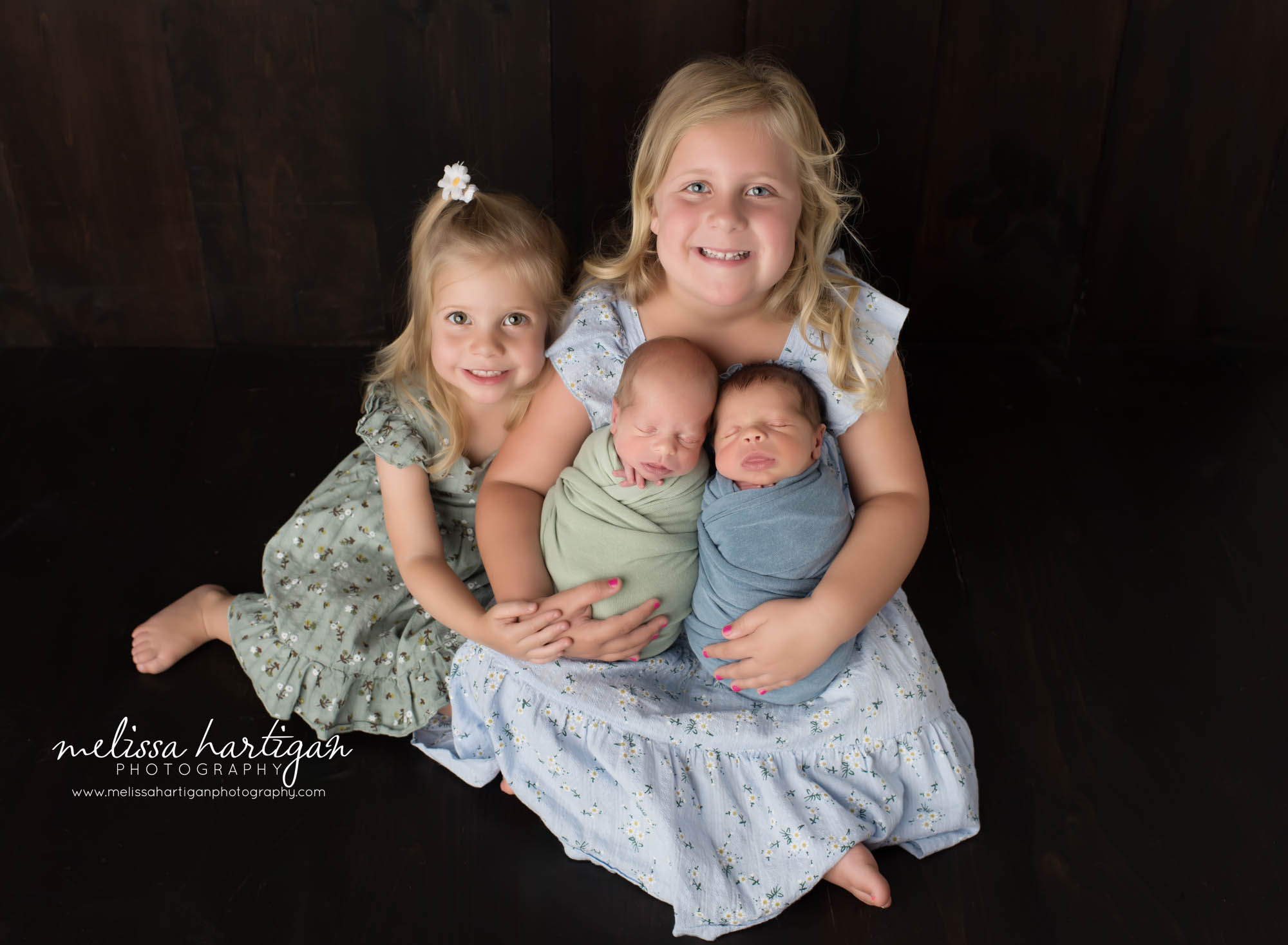 Big sisters posed holding their twin baby brothers Colchester CT Newborn Photography