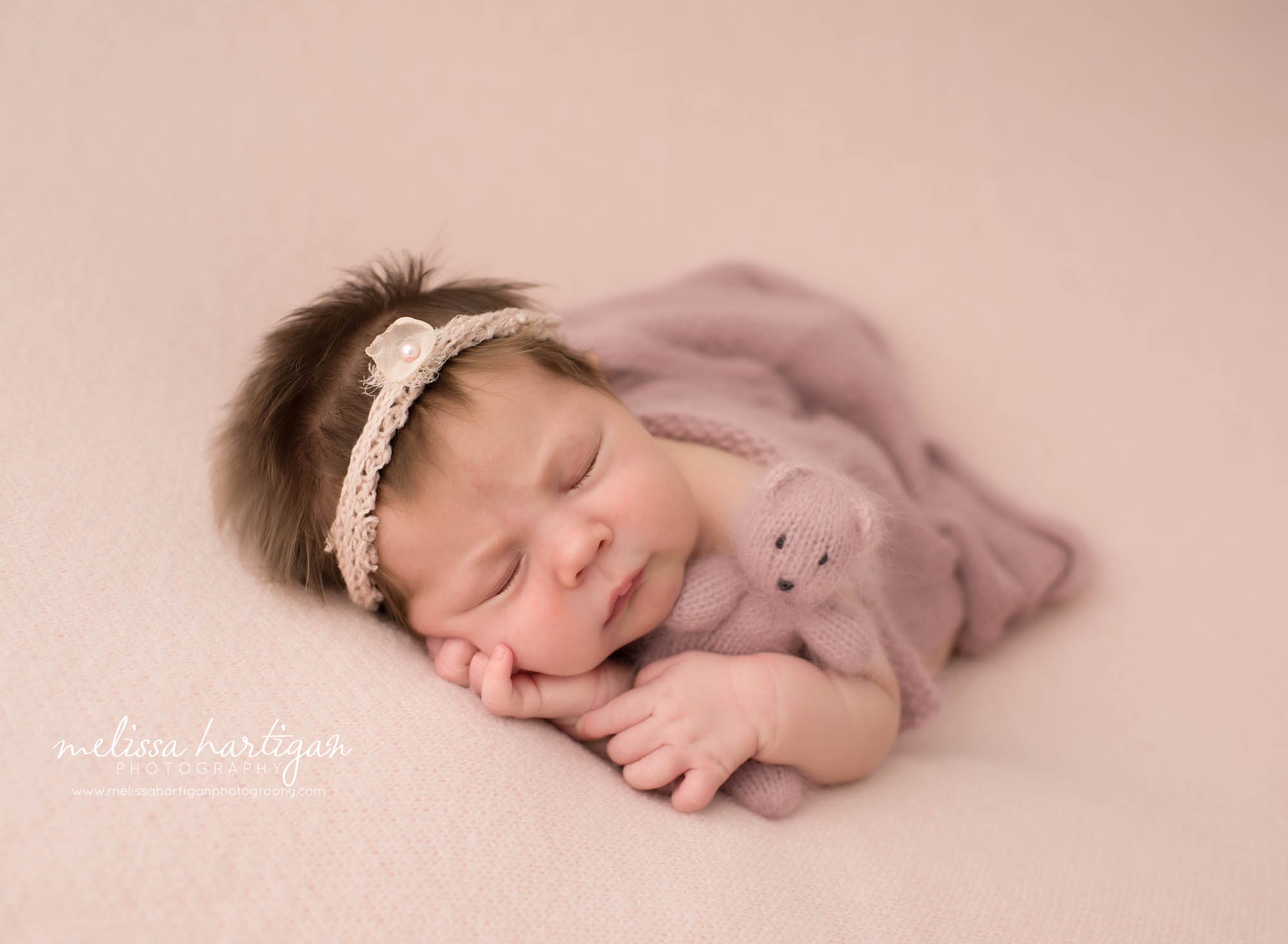 Newborn baby girl posed cuddling knitted pink teddy bear Hebron CT Newborn Photography