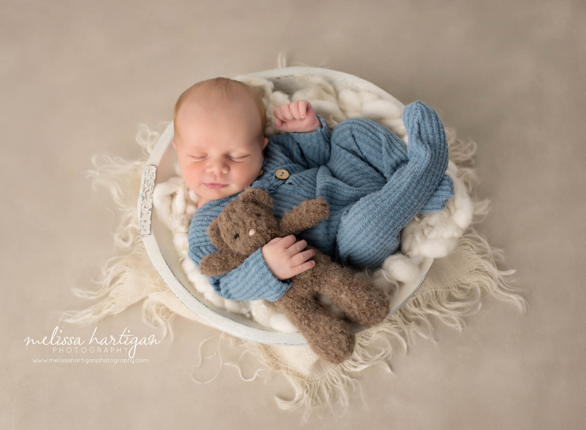 Newborn baby boy posed in wooden bowl holding teddy bear Newborn Photography Charlton MA