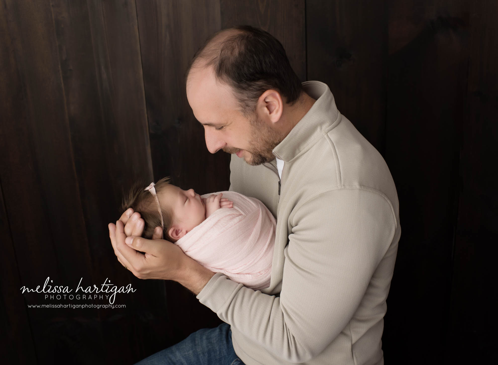 Dad holding newborn daughter in parents pose
