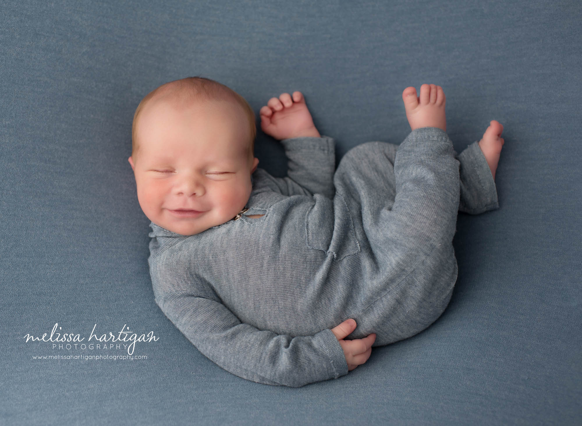 Newborn baby boy posed on blue backdrop Newborn Photography Charlton MA