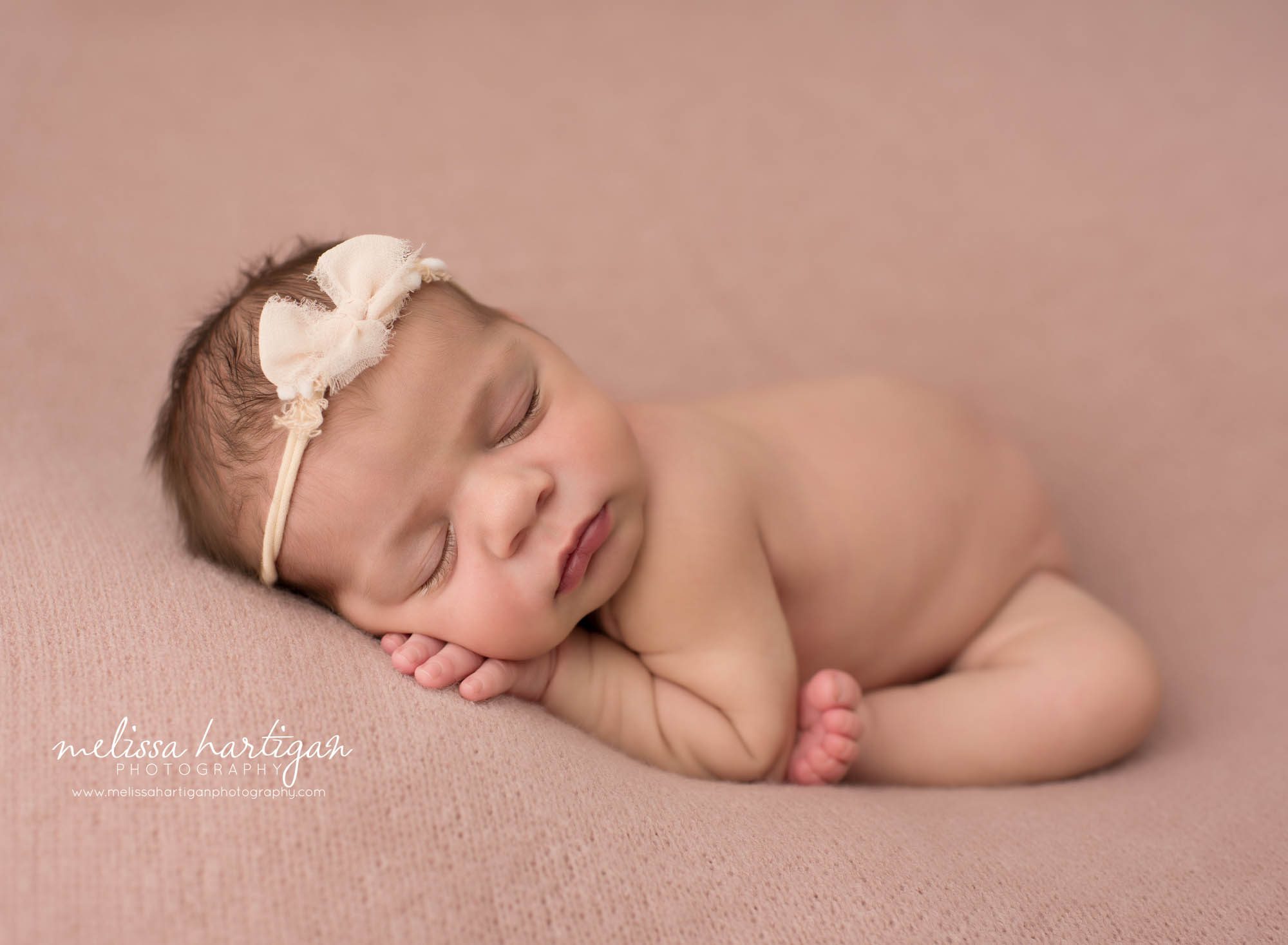 Newborn baby girl posed modified taco pose wearing cream headband Newborn Photography Norwich CT