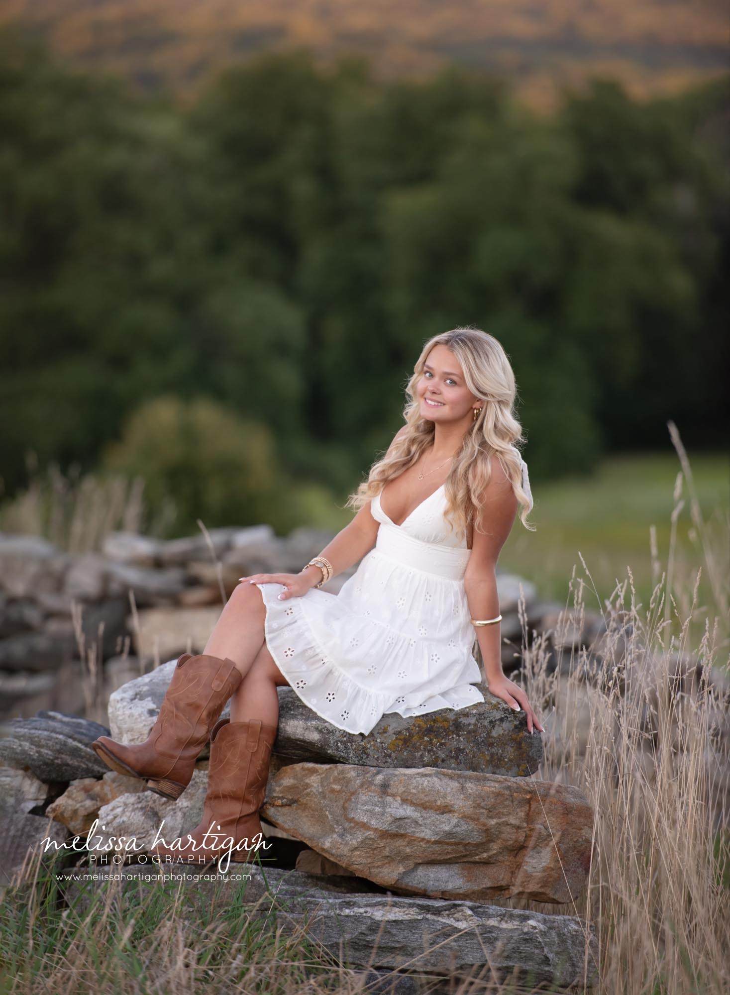 Girl sitting on rocks with legs crossed high school senior photoshoot in CT