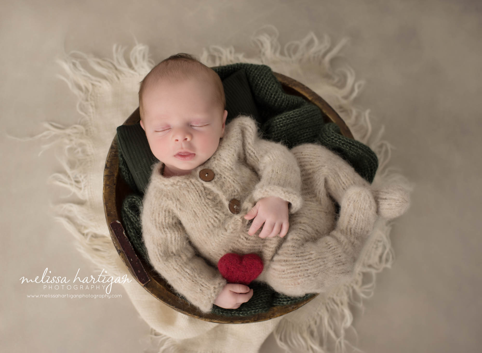 Newborn baby boy wearing beige knitted outfit posed in wooden bowl Columbia CT Newborn Photography