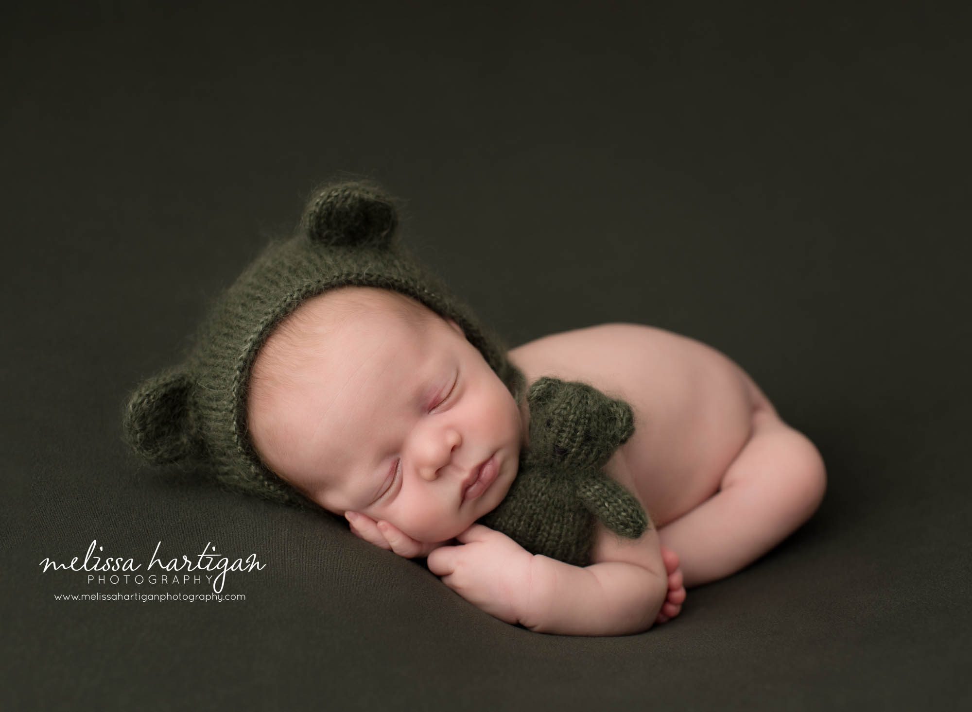 Newborn baby boy wearing green bear bonnet and holding knitted green bear teddy Columbia CT Newborn Photography
