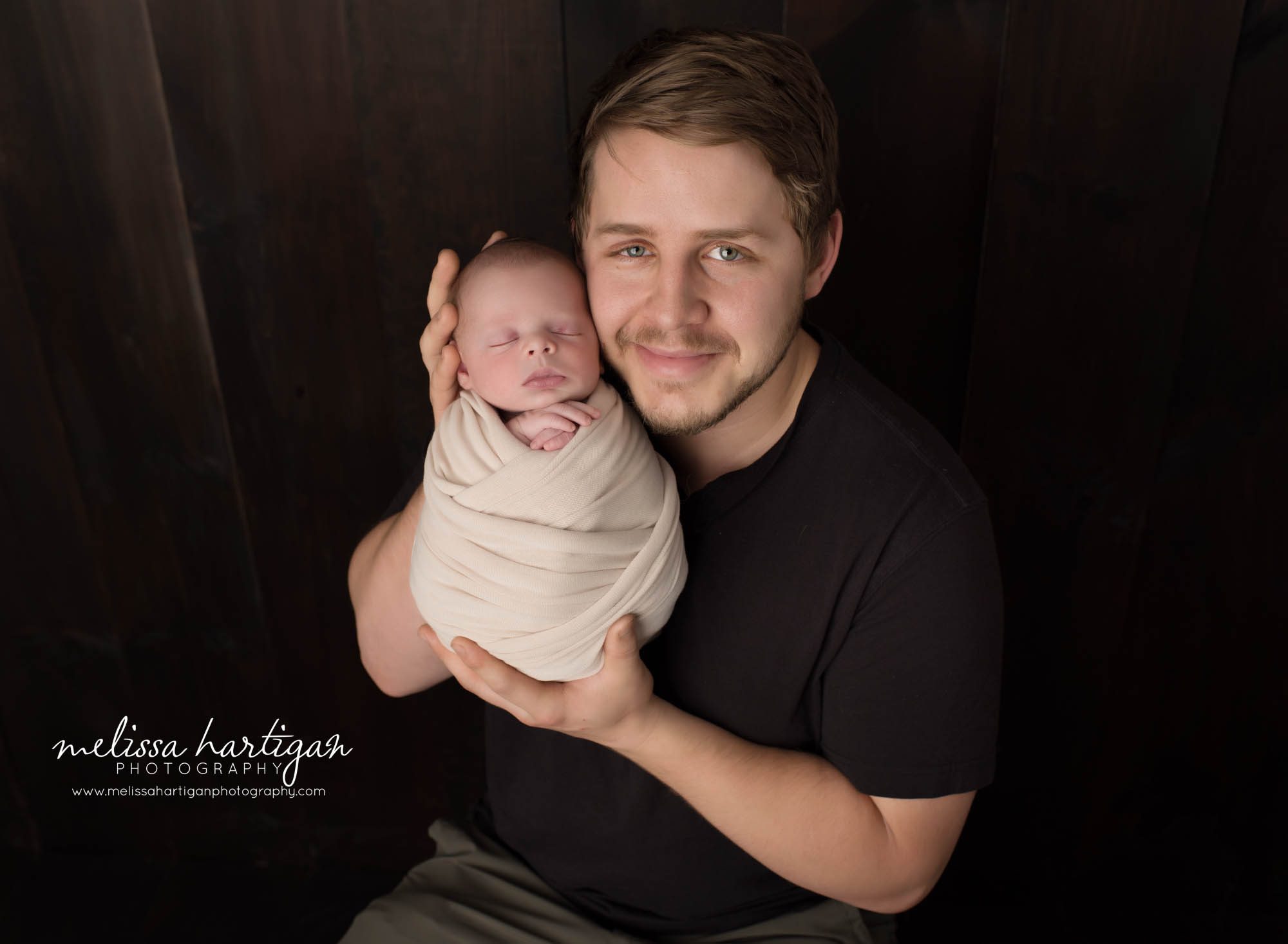 Dad holding newborn son in parents pose
