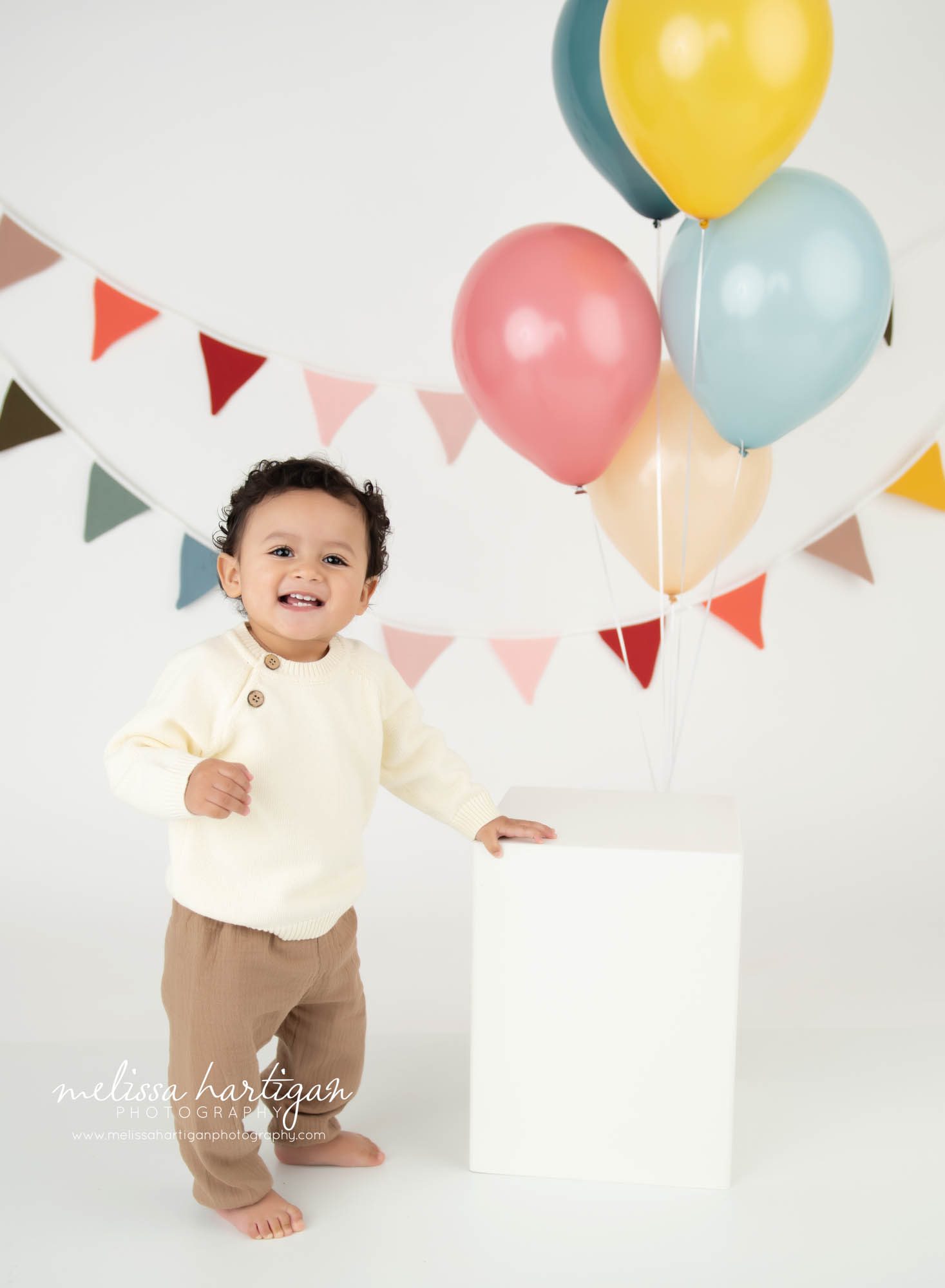 Baby boy standing at wooden box happy
